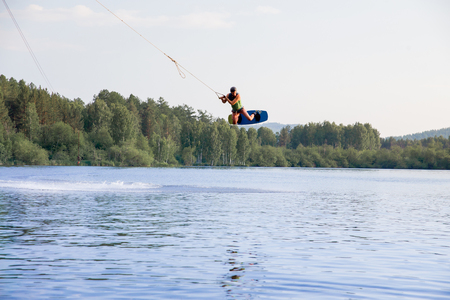 Young man riding wakeboard on a lakeの写真素材