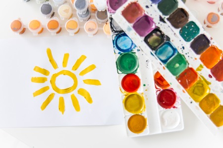Set of watercolor paints and paintbrushes on a tableの写真素材