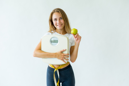 Fit woman measuring waist with measuring tapeの写真素材