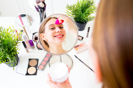 A portrait of woman with makeup brushes near faceの写真素材