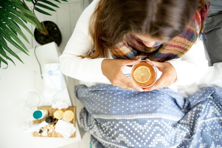 ill young girl with fever spending time at homeの写真素材