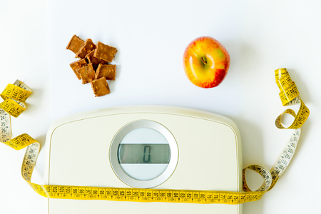 scales and and fruit on a floor, training and healthy lifestyle conceptの写真素材