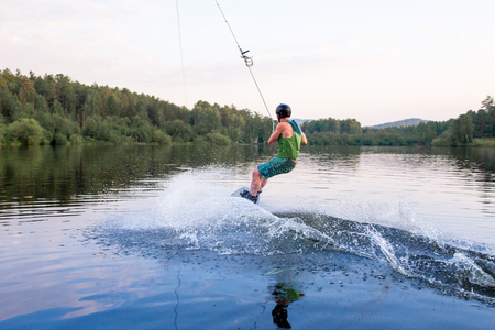 Young man riding wakeboard on a lakeの写真素材