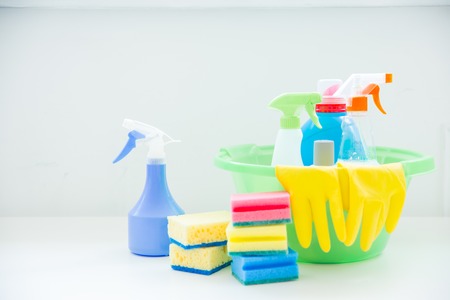 Bucket with cleaning supplies and tools on tableの写真素材