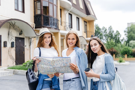Beautiful woman traveler holding location map in hands in a city