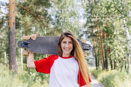 Beautiful skater woman riding on her longboard in the cityの写真素材