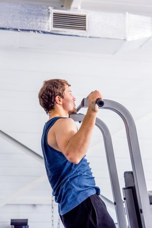 Young muscular man doing crossfit exercises in a gym