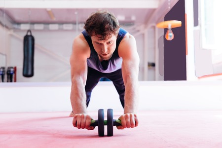 Young muscular man doing crossfit exercises in a gymの写真素材