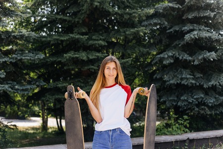 Beautiful skater woman riding on her longboard in the cityの写真素材