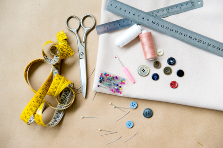set of sewing tools - scissors, needles, buttons, thread on a tableの写真素材