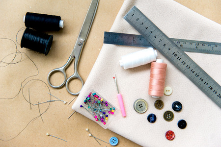 set of sewing tools - scissors, needles, buttons, thread on a tableの写真素材