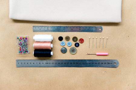 set of sewing tools - scissors, needles, buttons, thread on a tableの写真素材