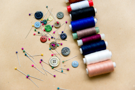 set of sewing tools - scissors, needles, buttons, thread on a tableの写真素材