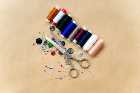 set of sewing tools - scissors, needles, buttons, thread on a tableの写真素材