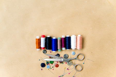 set of sewing tools - scissors, needles, buttons, thread on a tableの写真素材