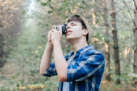 Young man traveler taking a photo in the nature