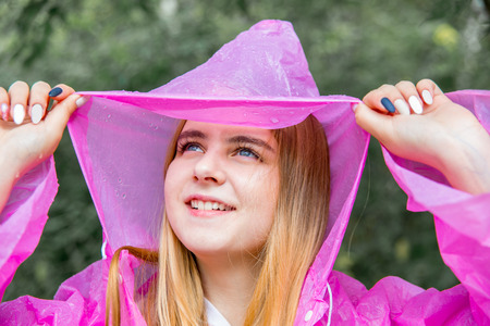woman in rubber boots and a raincoat walking in the rainの写真素材