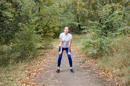 sporty fit girl jogging at park and doing exercises