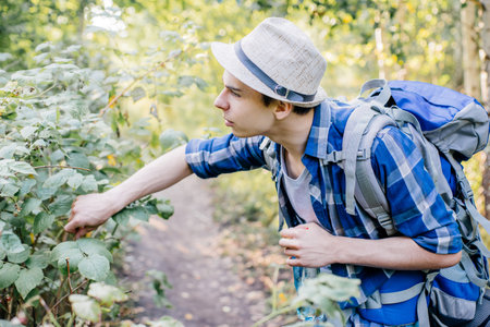 young traveler guy hiking with backpack in the nature