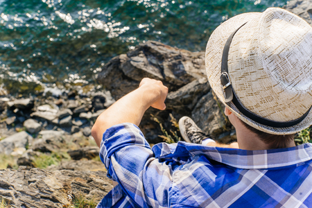 young male hiker is sitting and resting on a mounainの写真素材