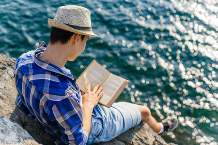 young male hiker is sitting and resting on a mounainの写真素材