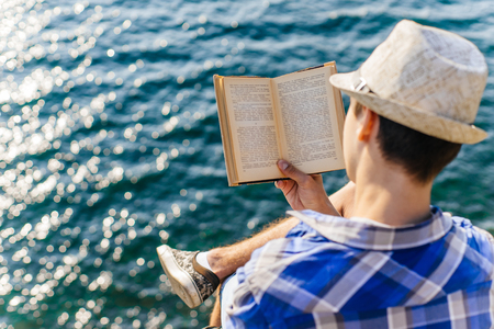 young male hiker is sitting and resting on a mounainの写真素材