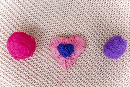 a pink heart knitted from woolen threadsの写真素材