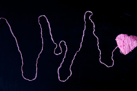 a pink heart knitted from woolen threadsの写真素材