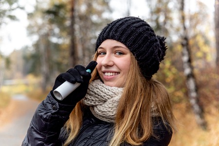 young woman with runny nose and using a nasal sprayの写真素材