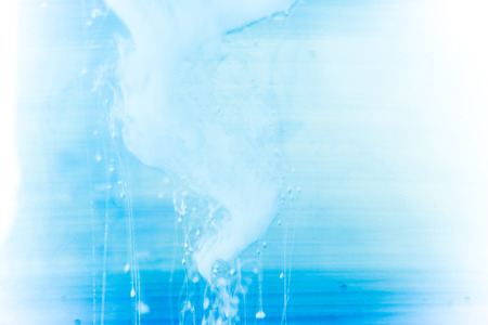 a drop of paint pouring in waterの写真素材