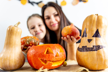 A mother and her daughter carving pumpkin togetherの写真素材