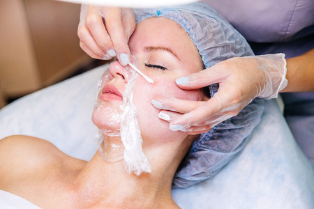 Young pretty woman enjoying a facial mask procedureの写真素材