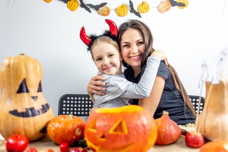 A mother and her daughter carving pumpkin togetherの写真素材