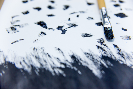 several paintbrushes with a painting on a tableの写真素材