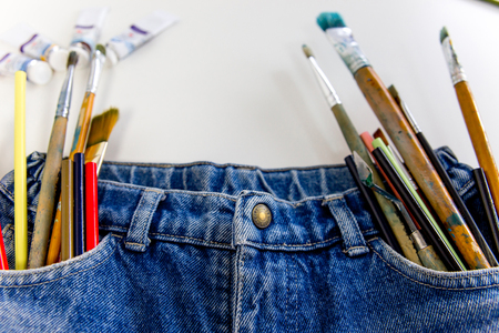 Multicolored pencils stick out of a jeans pocketの写真素材