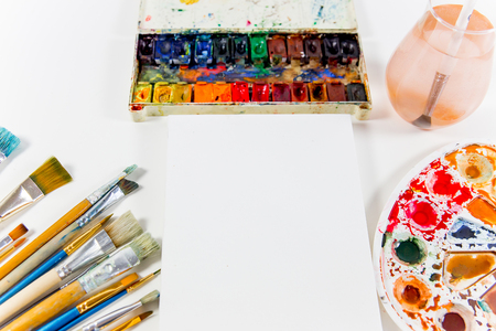 several paintbrushes with paint on a tableの写真素材