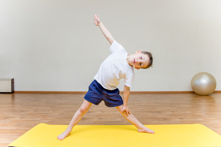 a little boy practicing yoga at homeの写真素材