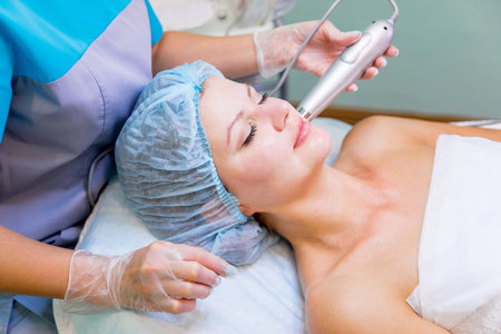 Young pretty woman enjoying a facial mask procedure