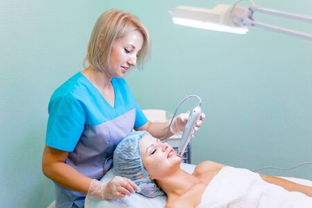 Young pretty woman enjoying a facial mask procedureの写真素材