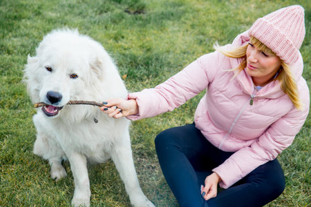 A pretty woman is walking her dog