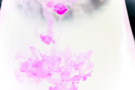 a drop of paint pouring in waterの写真素材