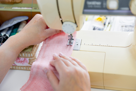 female hands are using a sewing machineの写真素材
