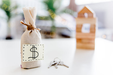 a model of a house with a bag of money
