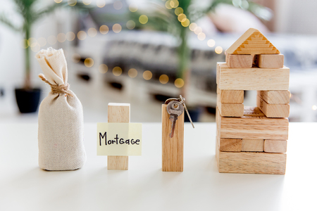 a model of a house with a bag of moneyの写真素材