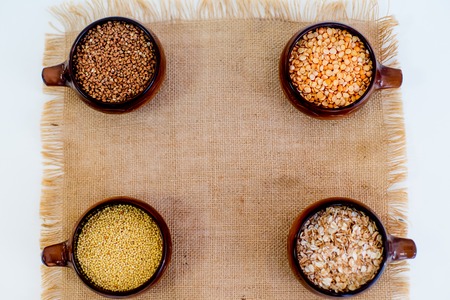 different types of groats in pots on a white backgroundの写真素材