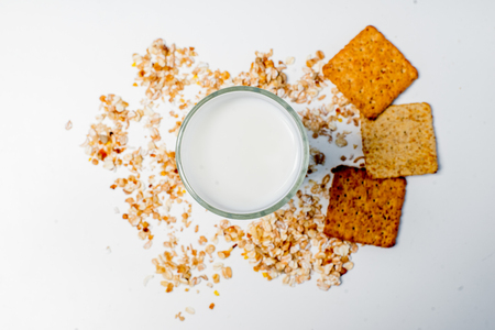 a glass of milk with bread and grainsの写真素材