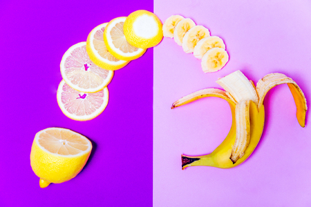 a banana and a lemon on colorful backgroundの写真素材