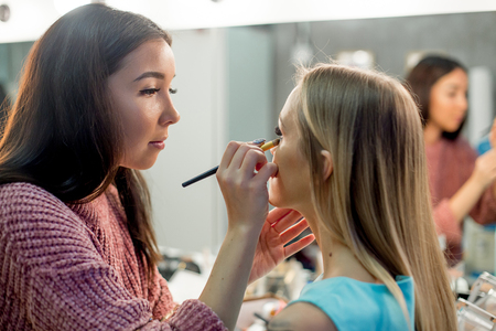 Professional makeup artist working on young girlの写真素材