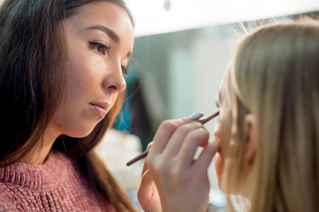 Professional makeup artist working on young girlの写真素材