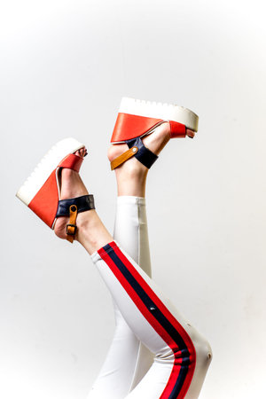 Female legs in white trousers and shoesの写真素材